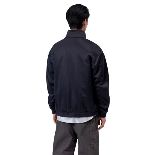 Casaco para homem Carhartt WIP Bolon Jacket em Dark Navy — vista traseira com modelo, meio corpo, gola alta e mangas raglan visíveis, combinado com camisa às riscas e calças cargo escuras.