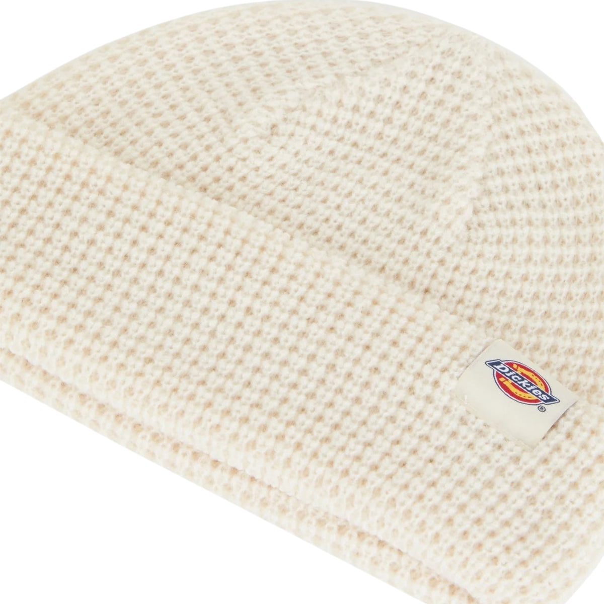 Gorro unissexo Dickies Woodworth Waffle Beanie em Ecru — close-up em ângulo da dobra frontal com label tecida Dickies em destaque.