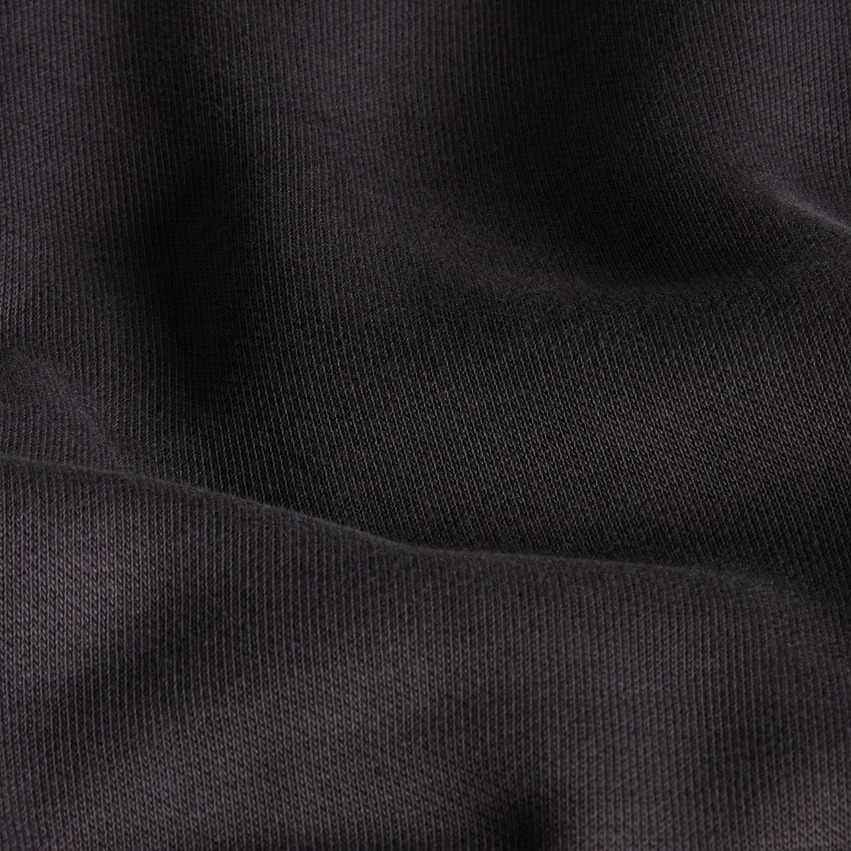 Pormenor da textura da malha cinzenta antracite da sweat The North Face NSE Slopes.
