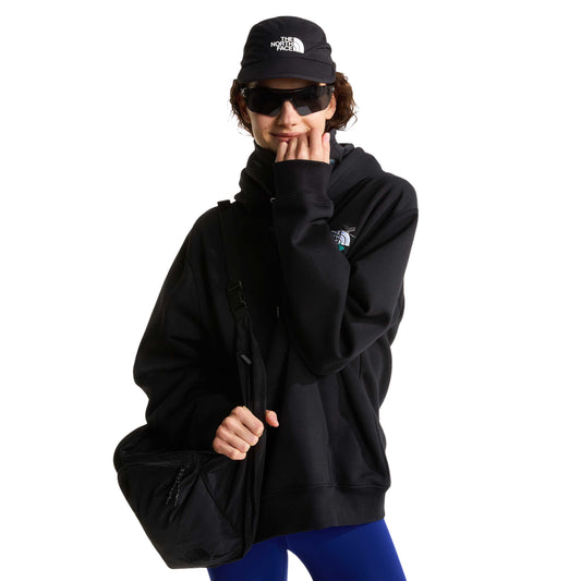 Modelo com sweat The North Face Off Piste Embro preta, boné, óculos de sol e bolsa preta ao ombro.