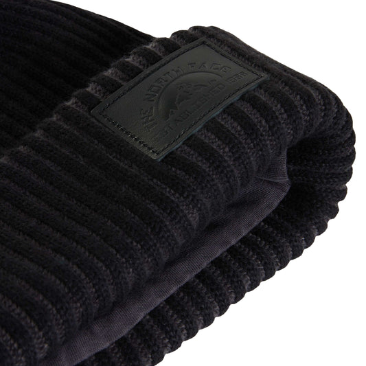 Pormenor da dobra do gorro The North Face Salty Lined SE preto, com emblema em relevo e forro interior visível.