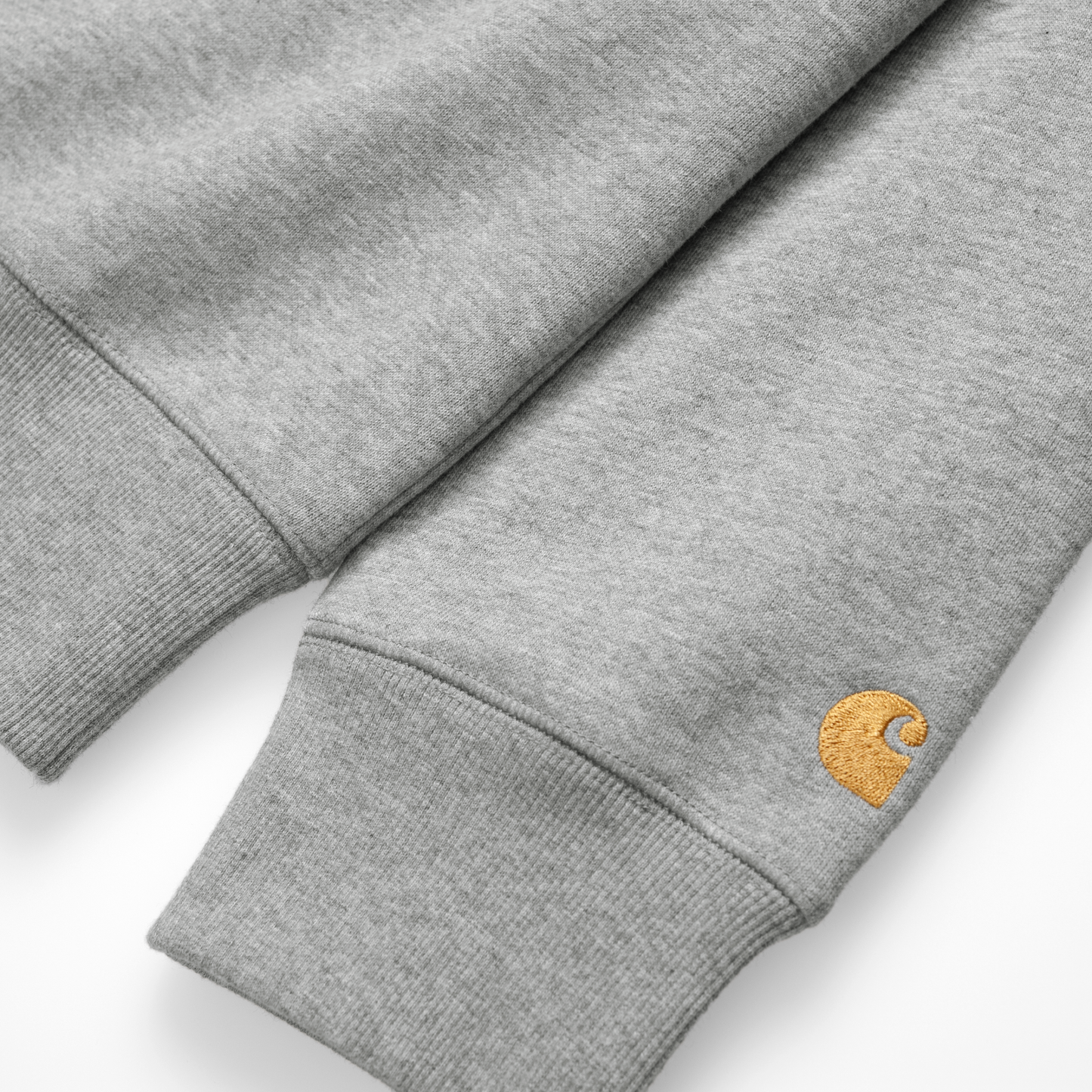 Carhartt WIP Chase Sweat em Grey Heather com detalhes em dourado. Foto de detalhe do bordado na manga.