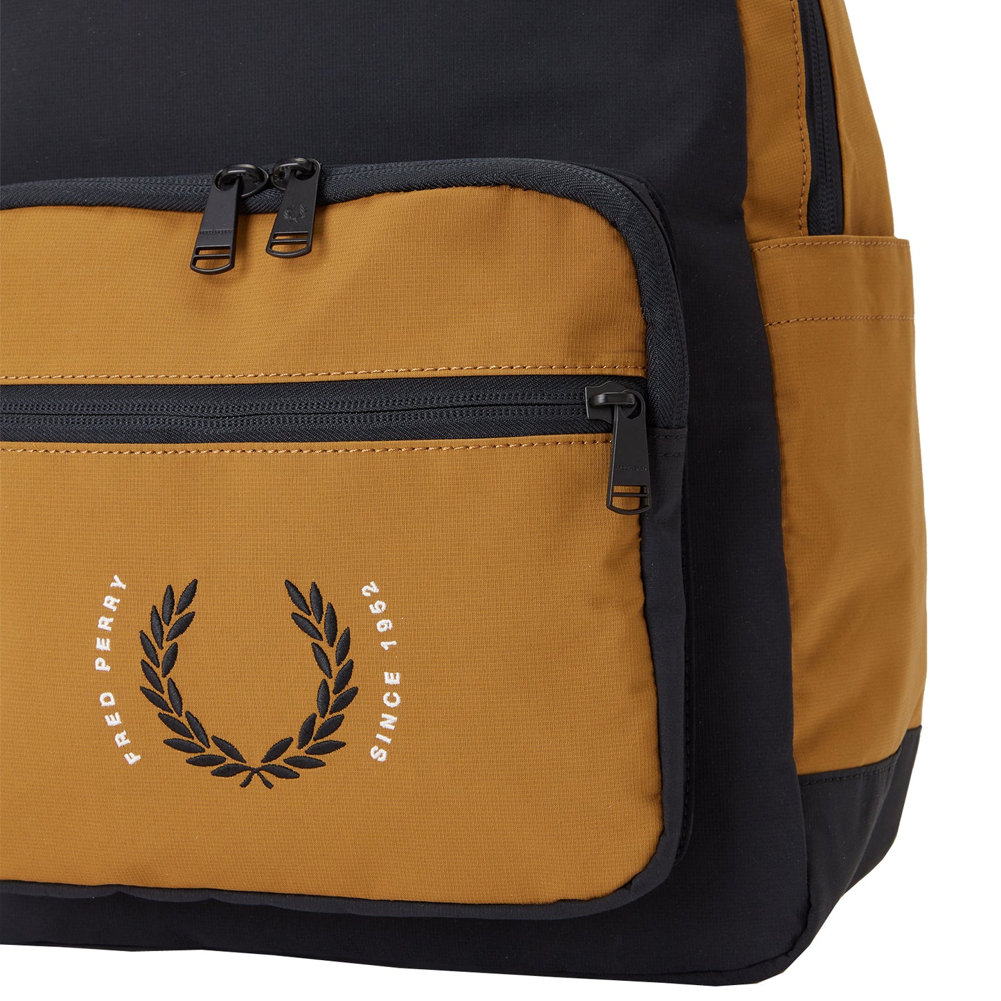Fred Perry Contrast Ripstop Backpack Black/Dark Caramel. Foto de detalhe do bolso da frente, bolso lateral e bordado.
