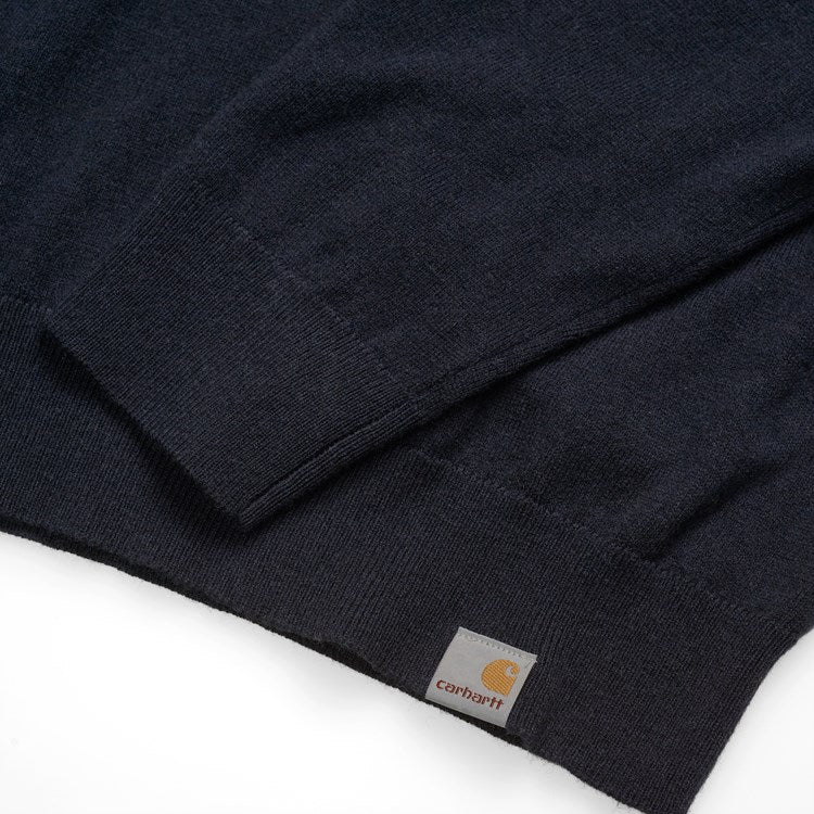 Carhartt WIP Playoff Turtleneck Sweater Dark Navy. Foto de detalhe do logotipo na parte de baixo da camisola e do punho.