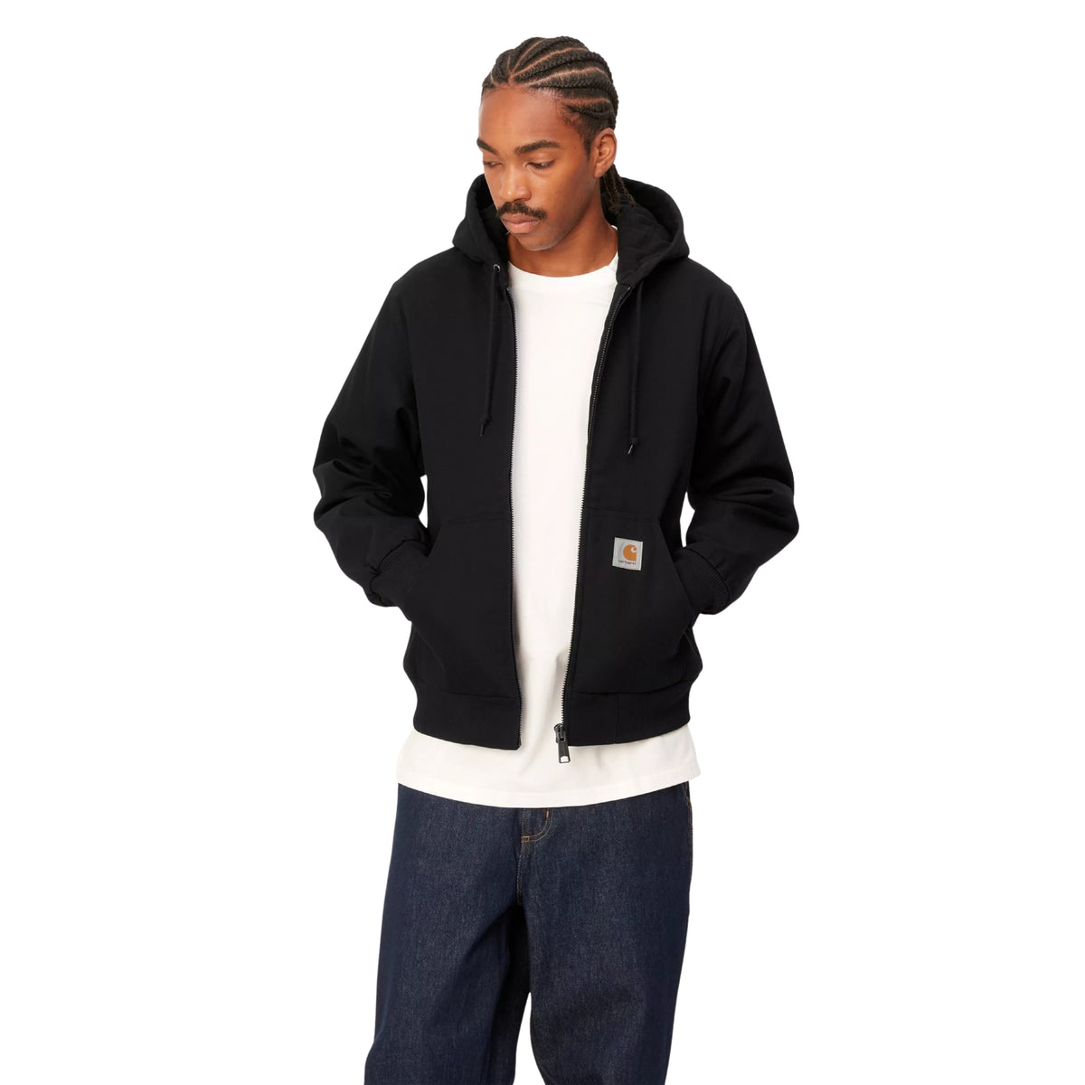 Casaco com carapuço Carhartt WIP Active em Preto Rigid, vista frontal em plano médio no modelo, usado aberto sobre uma t-shirt branca, com mãos nos bolsos e etiqueta quadrada visível.