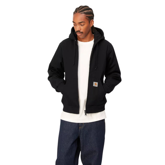 Casaco com carapuço Carhartt WIP Active em Preto Rigid, vista frontal em plano médio no modelo, usado aberto sobre uma t-shirt branca, com mãos nos bolsos e etiqueta quadrada visível.