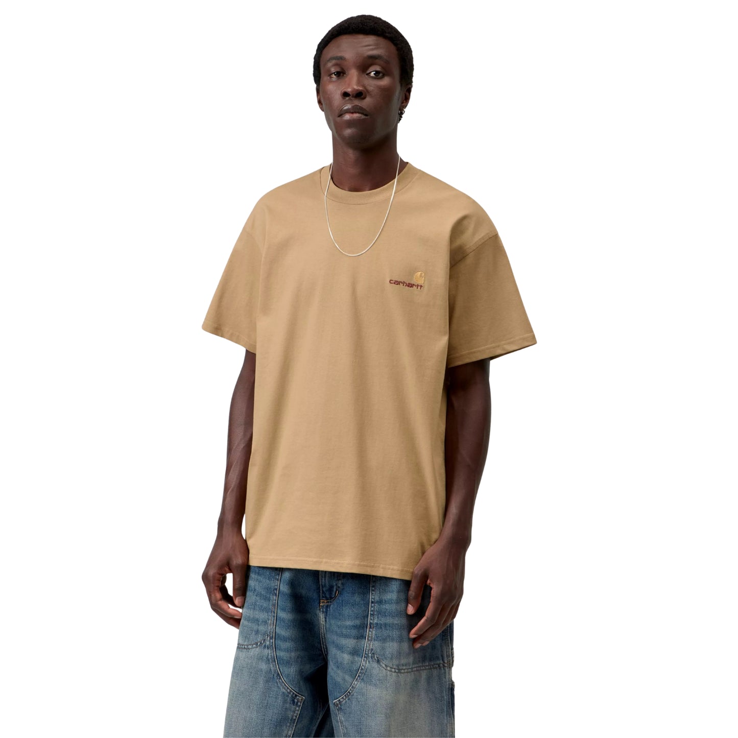 T-shirt Carhartt WIP S/S American Script em Dusty H Brown — modelo a usar a peça de frente, meio corpo superior, decote redondo, logótipo C amarelo-dourado com texto carhartt castanho em tom-sobre-tom no peito esquerdo, malha de algodão orgânico bege-camel arenoso, fundo branco.