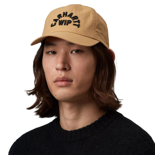 Boné Carhartt WIP Arch Script Cap em Dusty H Brown — modelo com boné de cinco painéis em nylon amarelo-camel, bordado gráfico CARHARTT WIP em arco a preto na frente e pala rígida e plana, fundo branco.