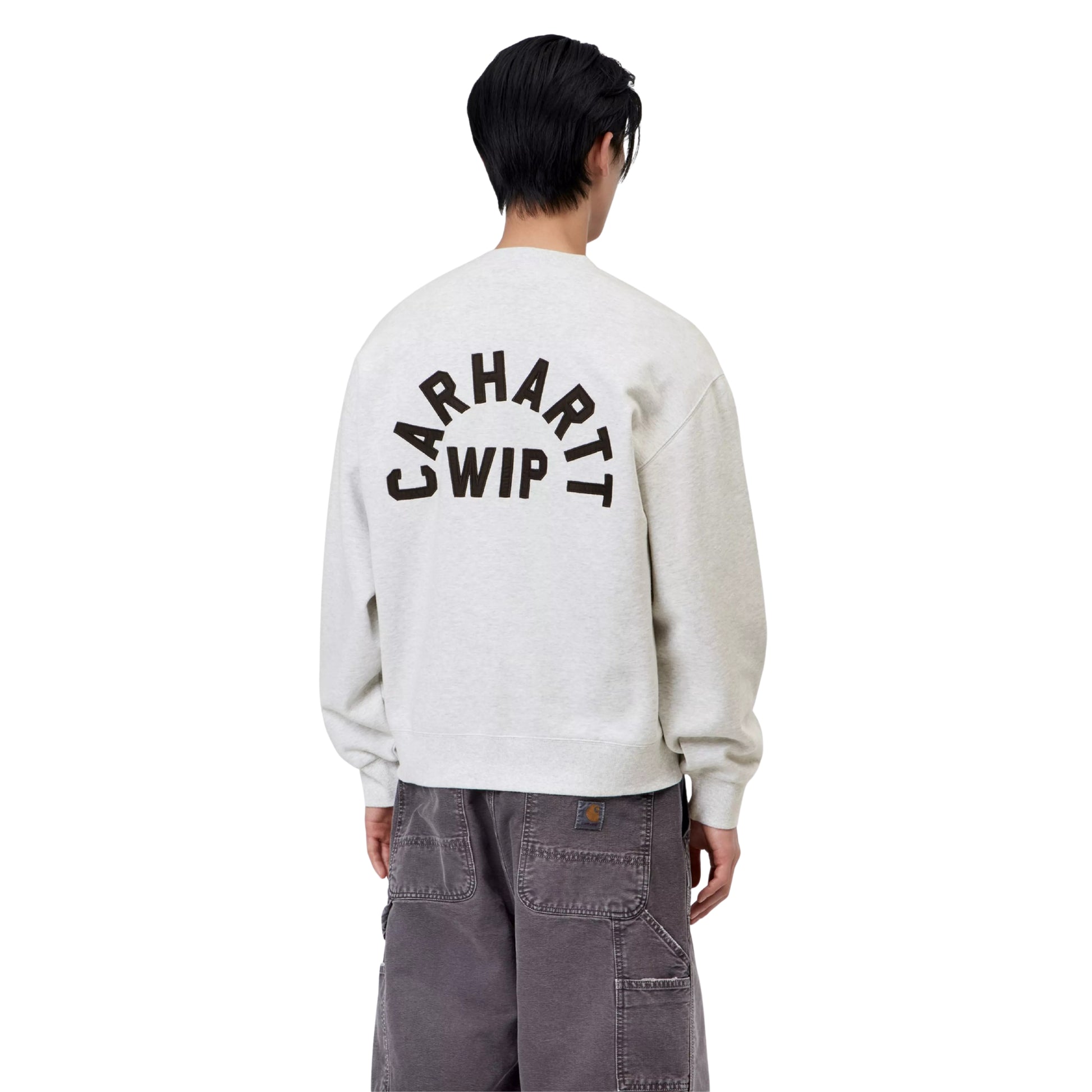 Sweat Carhartt WIP Arch Script em Ash Heather / Dark Navy Stone Washed — modelo masculino de costas, meio corpo, calças cargo Carhartt WIP double knee em cinza escuro stone washed, bordado em arco "Carhartt WIP" em Dark Navy nas costas visível, costuras dos ombros caídas e punhos canelados visíveis, fundo branco.