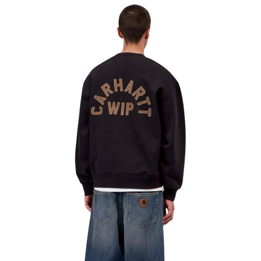 Sweat Carhartt WIP Arch Script em Black / Hamilton Brown Stone Washed — modelo masculino de costas, meio corpo, calças Carhartt WIP largas em denim azul lavado com patch castanho nos bolsos traseiros, bordado em arco "Carhartt WIP" em Hamilton Brown nas costas visível, costuras dos ombros caídas e punhos canelados visíveis, fundo branco.