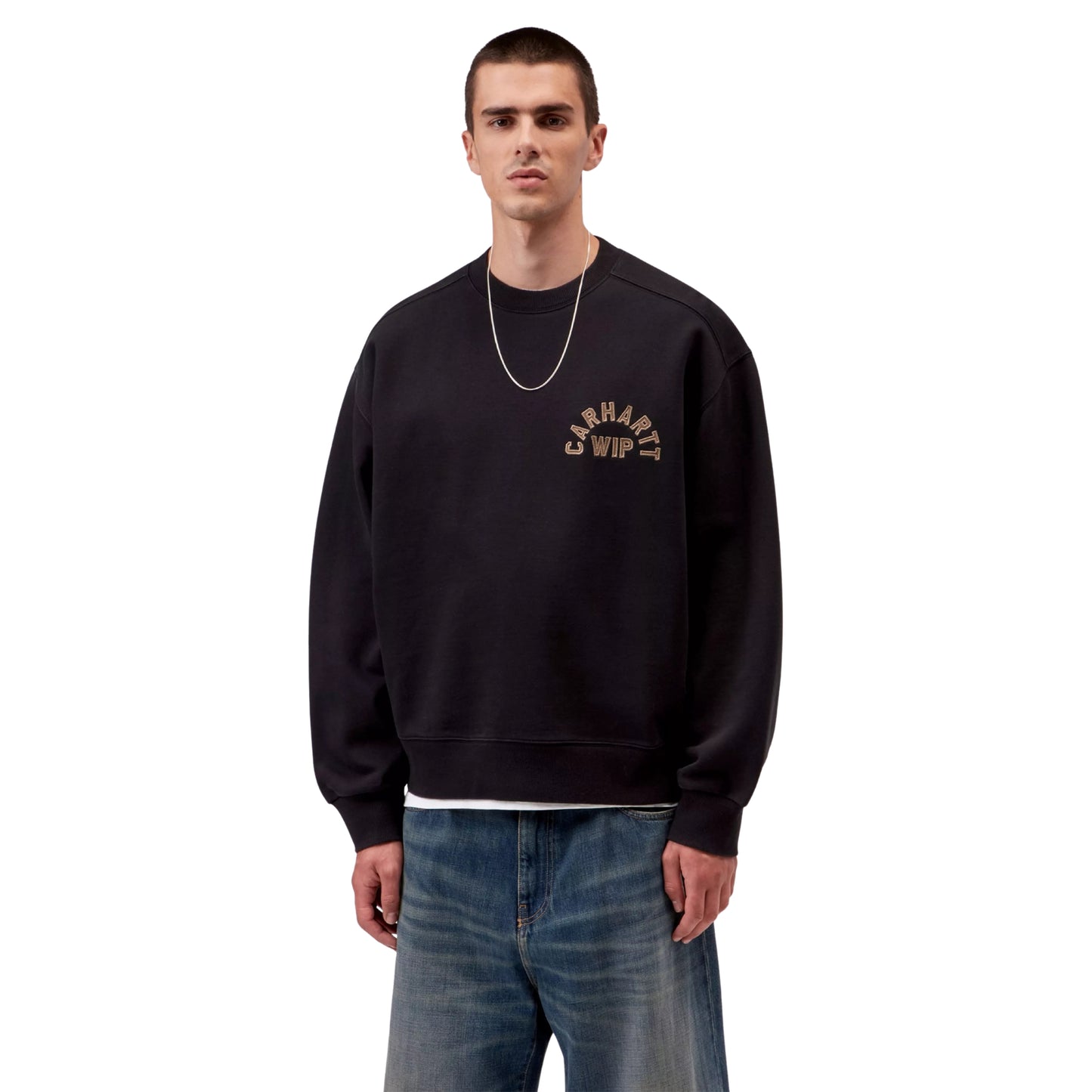 Sweat Carhartt WIP Arch Script em Black / Hamilton Brown Stone Washed — modelo masculino de frente, meio corpo, calças Carhartt WIP largas em denim azul lavado, colar fino dourado, bordado em arco "Carhartt WIP" em Hamilton Brown no peito esquerdo visível, corte balloon e decote redondo visíveis, fundo branco.