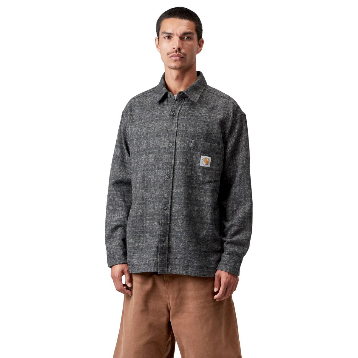 Camisa de manga comprida Carhartt WIP L/S Bagley em Bagley Check Preto — modelo masculino de frente, meio corpo, xadrez cinzento antracite mesclado com fios contrastantes, colarinho de gola clássico, fecho de botão, bolso de peito com Square Label Carhartt WIP dourada, corte loose, calças wide-leg camel, fundo branco.