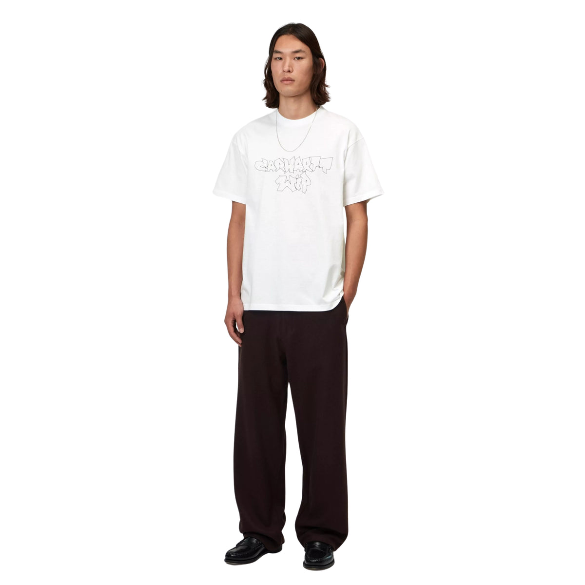 T-shirt de manga curta Carhartt WIP S/S Blinkerfluid em Branco — modelo masculino de frente, corpo inteiro, t-shirt branca com gráfico graffiti outline Carhartt WIP em cinza no peito, loose fit, calças largas pretas, sapatos pretos, fundo branco.