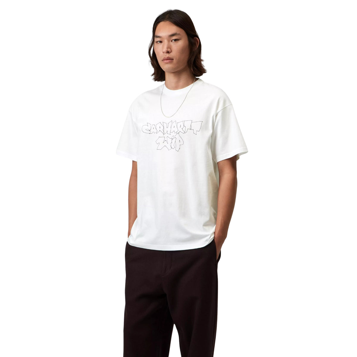 T-shirt de manga curta Carhartt WIP S/S Blinkerfluid em Branco — modelo masculino de frente, meio corpo, t-shirt branca com gráfico graffiti outline Carhartt WIP em cinza no peito, decote redondo, loose fit, calças largas pretas, fundo branco.