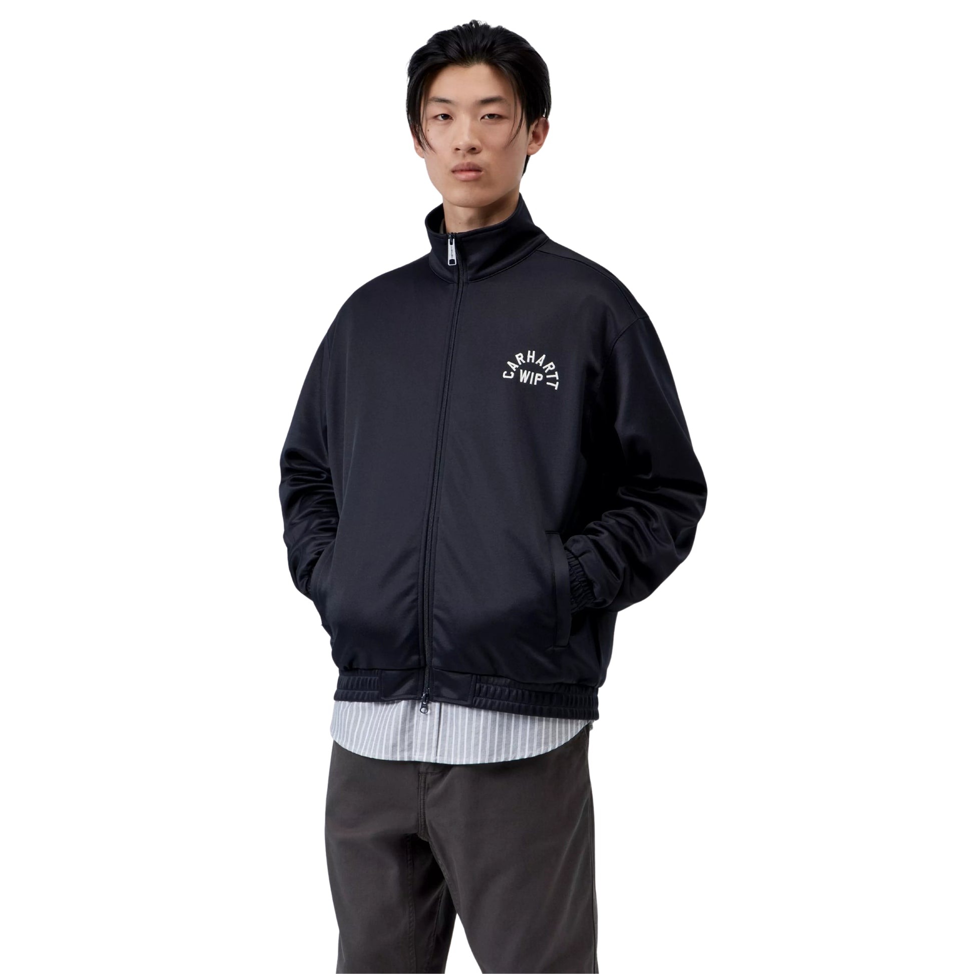 Casaco para homem Carhartt WIP Bolon Jacket em Dark Navy — vista frontal com modelo, meio corpo, fecho fechado, bordado tipográfico Carhartt WIP no peito esquerdo, combinado com camisa às riscas e calças cargo escuras.