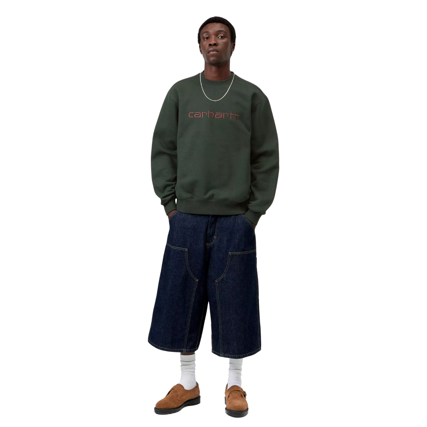 Sweatshirt Carhartt WIP Carhartt Sweat em Dark Scarab — modelo masculino de frente, corpo inteiro, cabelo curto escuro, corrente fina dourada ao pescoço, logótipo Script "carhartt." bordado ao peito em Palisander visível, mãos nos bolsos das calças, calças cargo wide-leg denim azul-escuro Carhartt WIP, meias brancas altas, sapatos loafer em camurça camel, malha escovada verde Dark Scarab, fundo branco.