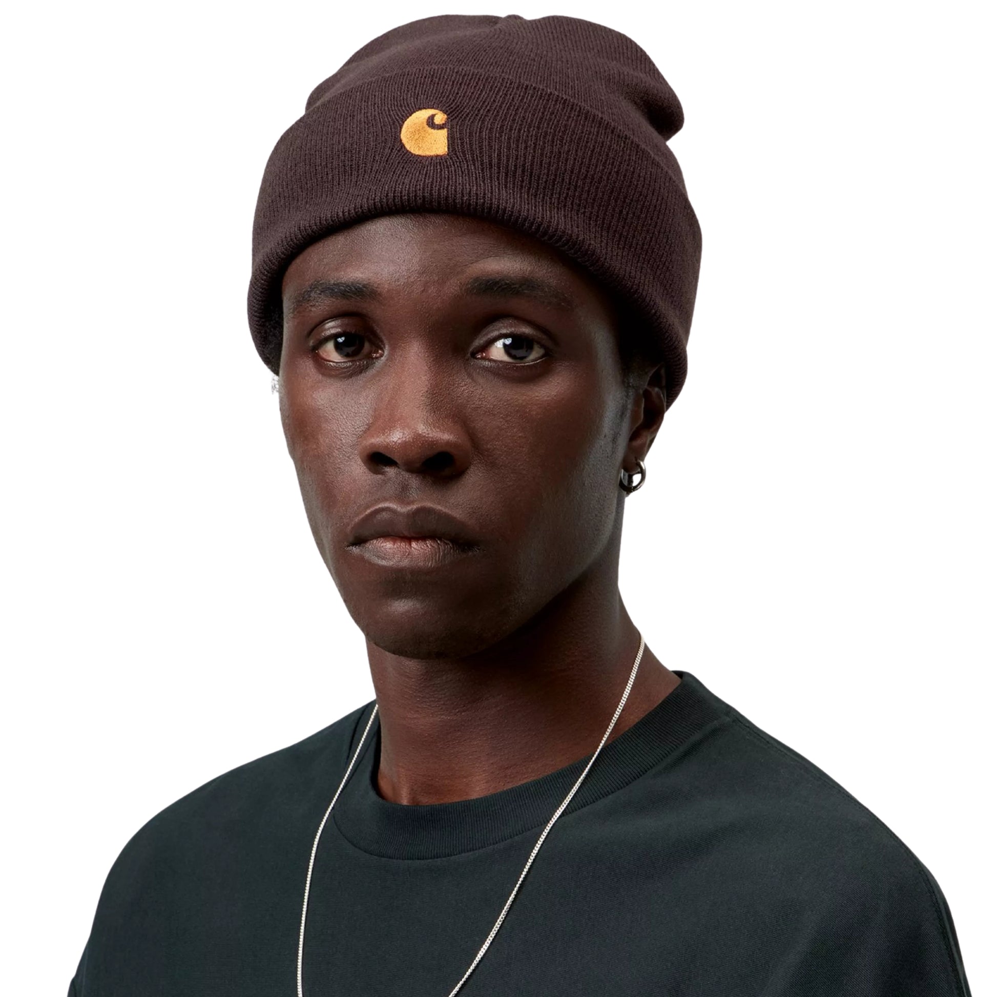 Gorro Carhartt WIP Chase Beanie em Palisander / Gold — modelo com gorro castanho avermelhado, logo "C" dourado visível na frente, combinado com t-shirt verde escura.