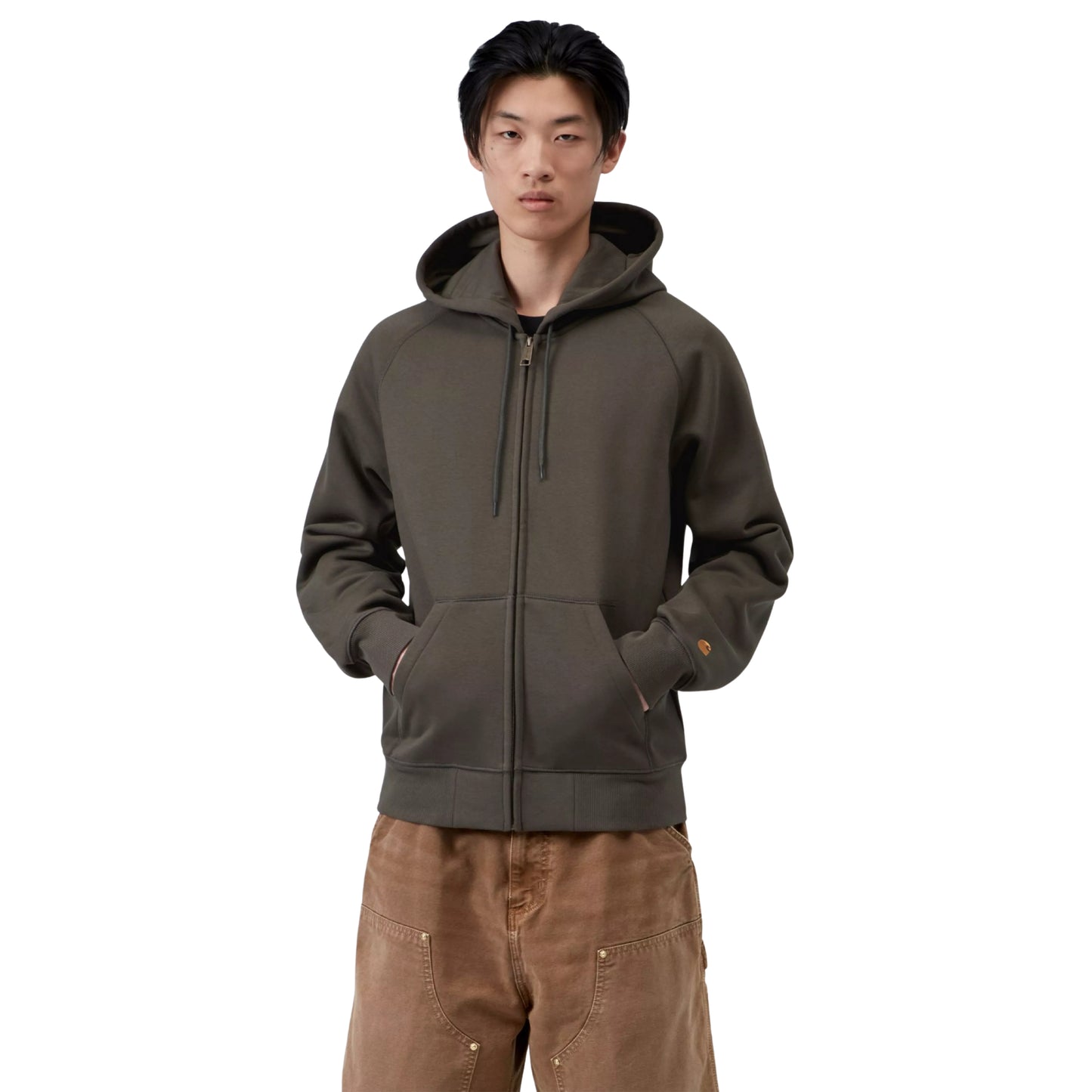 Casaco com carapuço Carhartt WIP Hooded Chase Jacket em Shungite / Gold — vista frontal com modelo, meio corpo, fecho fechado, logo "C" dourado na manga esquerda, combinado com t-shirt às riscas e calças cargo castanhas Carhartt WIP.