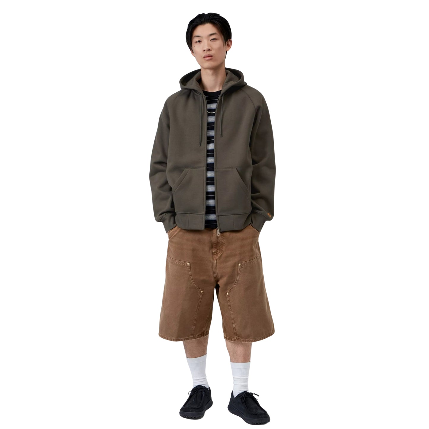 Casaco com carapuço Carhartt WIP Hooded Chase Jacket em Shungite / Gold — look completo com modelo, corpo inteiro, fecho fechado, mãos nos bolsos, combinado com calças cargo castanhas largas, meias brancas e sapatilhas pretas.