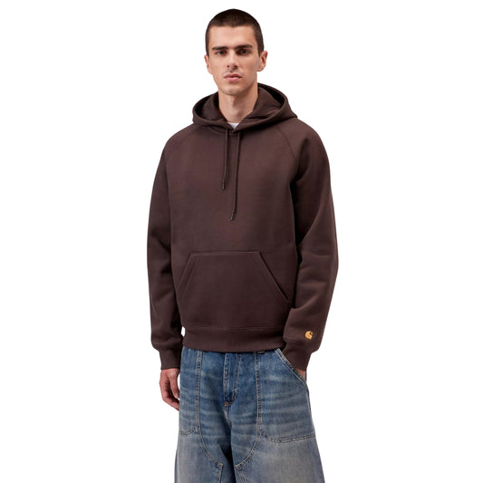 Sweat com carapuço para homem Carhartt WIP Chase em Palisander / Gold — vista frontal com modelo, meio corpo, logo "C" dourado visível na manga esquerda, combinado com calças de ganga largas.