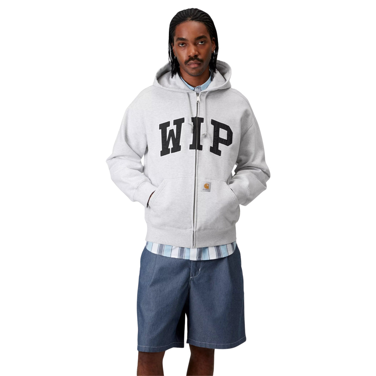 Sweat jacket com capuz Carhartt WIP Hooded WIP em ash heather stone washed — modelo masculino de frente, corpo inteiro, aplique WIP em arco no peito com fecho fechado, mãos nos bolsos canguru, logótipo Carhartt dourado na anca, calções azul-slate, botas bege, fundo branco.