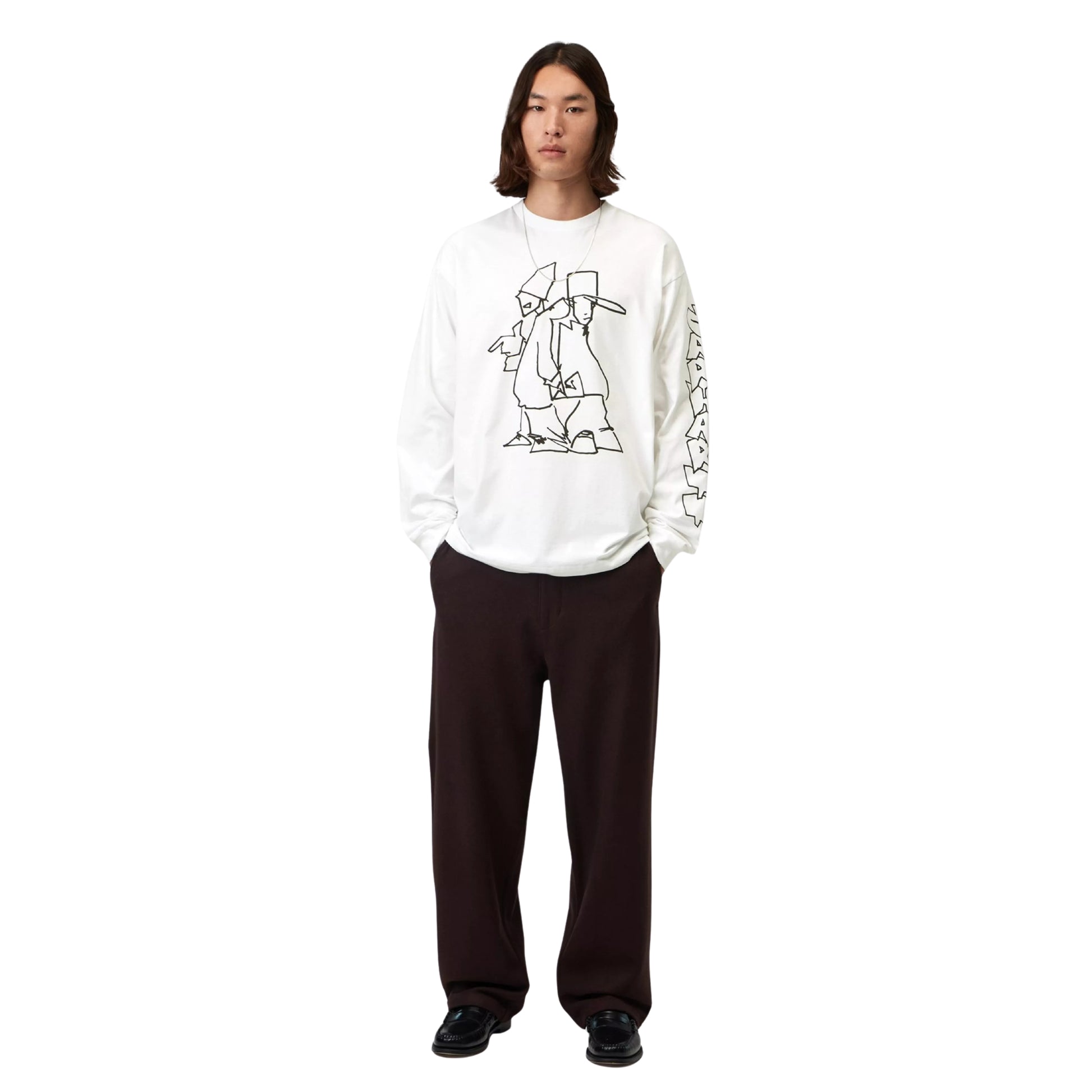 T-shirt de manga comprida Carhartt WIP L/S Blinkerfluid em Branco — modelo masculino de frente, corpo inteiro, t-shirt branca com gráfico line art de duas figuras no peito e lettering graffiti outline na manga direita, loose fit, calças largas pretas, sapatos pretos, fundo branco.
