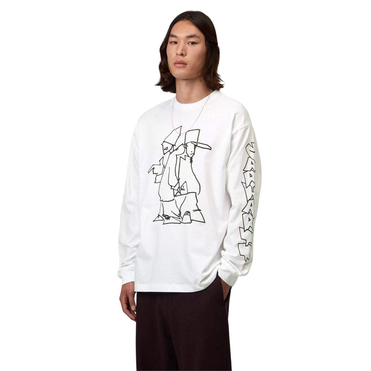 T-shirt de manga comprida Carhartt WIP L/S Blinkerfluid em Branco — modelo masculino de três quartos frontal, meio corpo, t-shirt branca com gráfico line art de duas figuras com chapéu e roupa larga no peito e lettering graffiti outline Carhartt WIP na manga direita, decote redondo, loose fit, calças largas pretas, fundo branco.