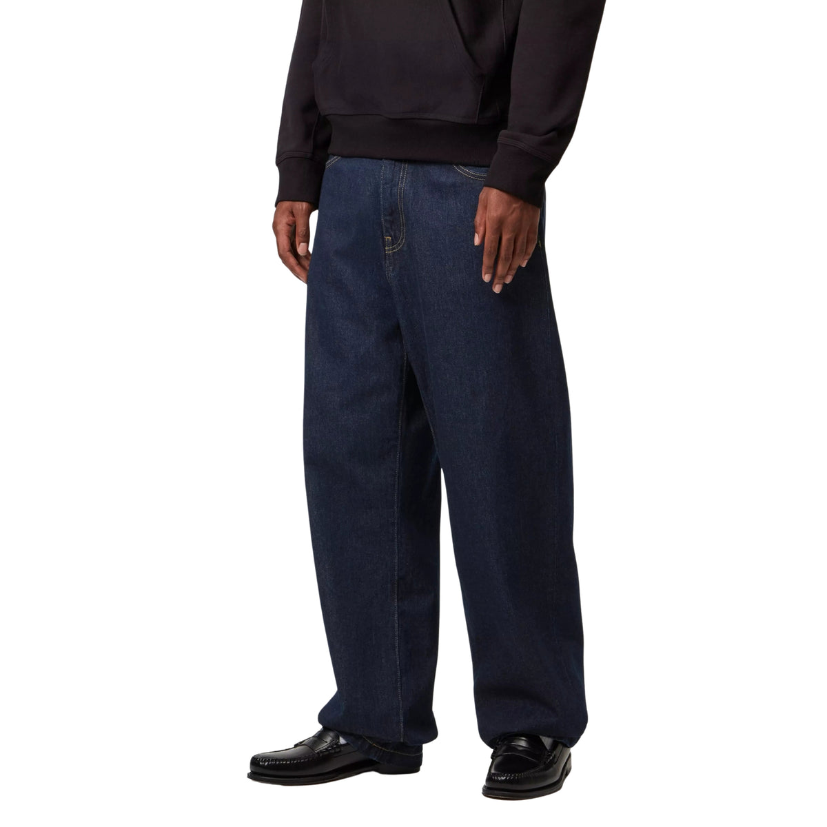 Calças de ganga Carhartt WIP Landon em azul Rinsed, vista frontal a três quartos em modelo, mostrando o corte largo nas coxas e as pernas afuniladas.