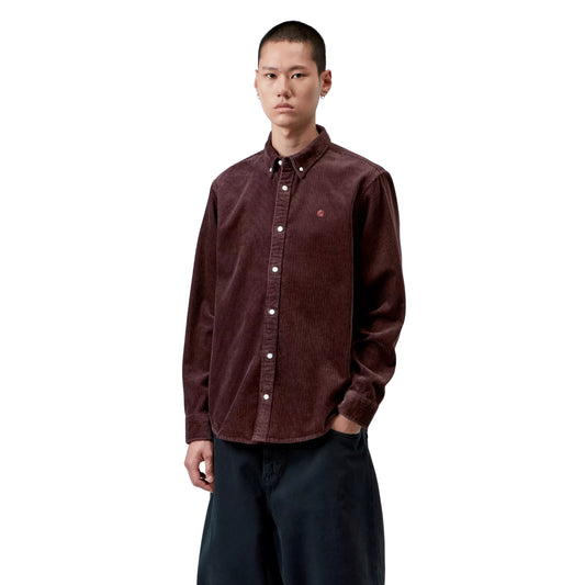Camisa de manga comprida Carhartt WIP Madison Cord em Amarone, vista frontal em plano médio no modelo, com textura de bombazina, botões claros, gola button-down e logótipo C bordado no peito esquerdo.