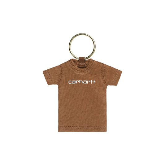 Porta-chaves Carhartt WIP Mini Script T-Shirt Keychain em Hamilton Brown — produto isolado, berloque em forma de mini t-shirt em malha de algodão castanha Hamilton Brown com logotipo "carhartt" impresso a branco ao peito, decote redondo canelado, mangas curtas, preso a anel metálico dourado por aba de tecido castanho, fundo branco.