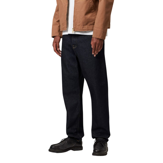 Calças de ganga Carhartt WIP Newel em azul One Wash, vestidas por modelo de frente a três quartos, mostrando o corte relaxado e as pernas ligeiramente afuniladas.
