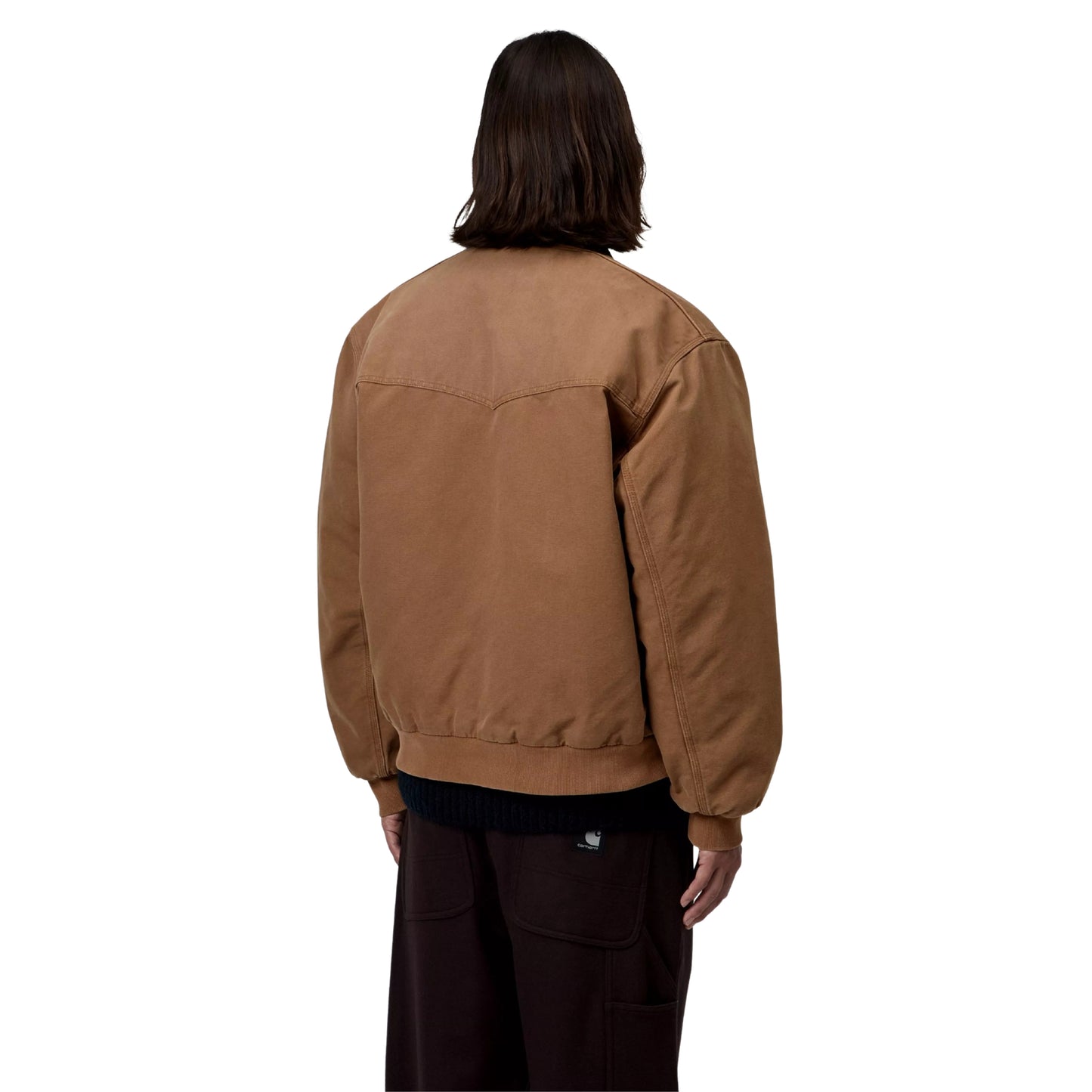 Casaco Carhartt WIP OG Santa Fe em WIP H Brown / Tobacco — modelo masculino de costas, meio corpo, lona Dearborn camel, costuras em arco no painel traseiro, faixa inferior em malha canelada camel, gola bombazine castanho-escuro, calças wide-leg bordeaux-escuro, fundo branco.