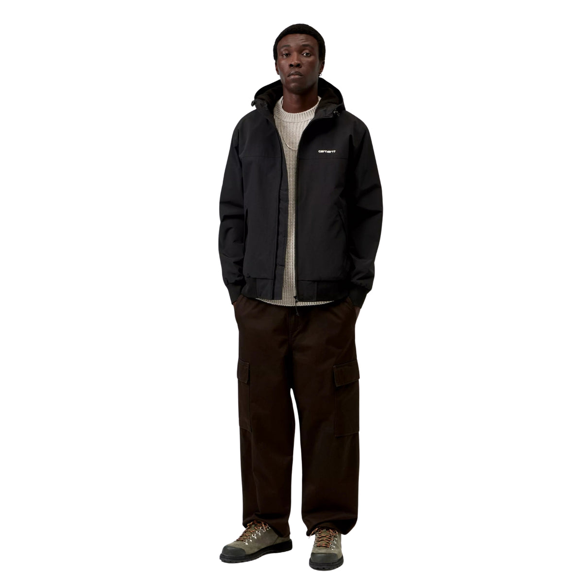 Casaco com carapuço Carhartt WIP Hooded Sail em Preto/Branco, vista frontal de corpo inteiro no modelo, usado aberto sobre uma camisola de malha clara, com calças cargo castanhas e calçado cinzento.