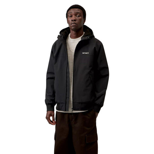 Casaco com carapuço Carhartt WIP Hooded Sail em Preto/Branco, vista frontal em plano médio no modelo, usado aberto sobre uma camisola de malha clara, com logótipo branco no peito e punhos e bainha canelados.