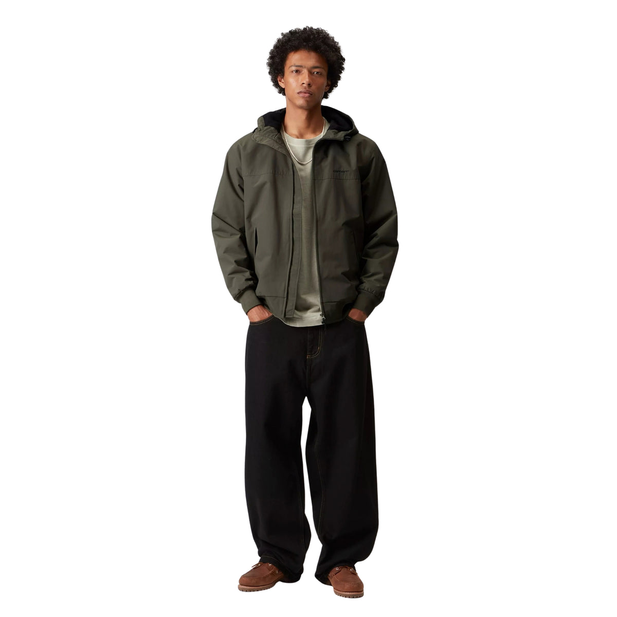 Casaco com carapuço Carhartt WIP Hooded Sail em Cypress, vista frontal de corpo inteiro no modelo, usado aberto sobre uma t-shirt clara, com jeans largos pretos e calçado castanho.