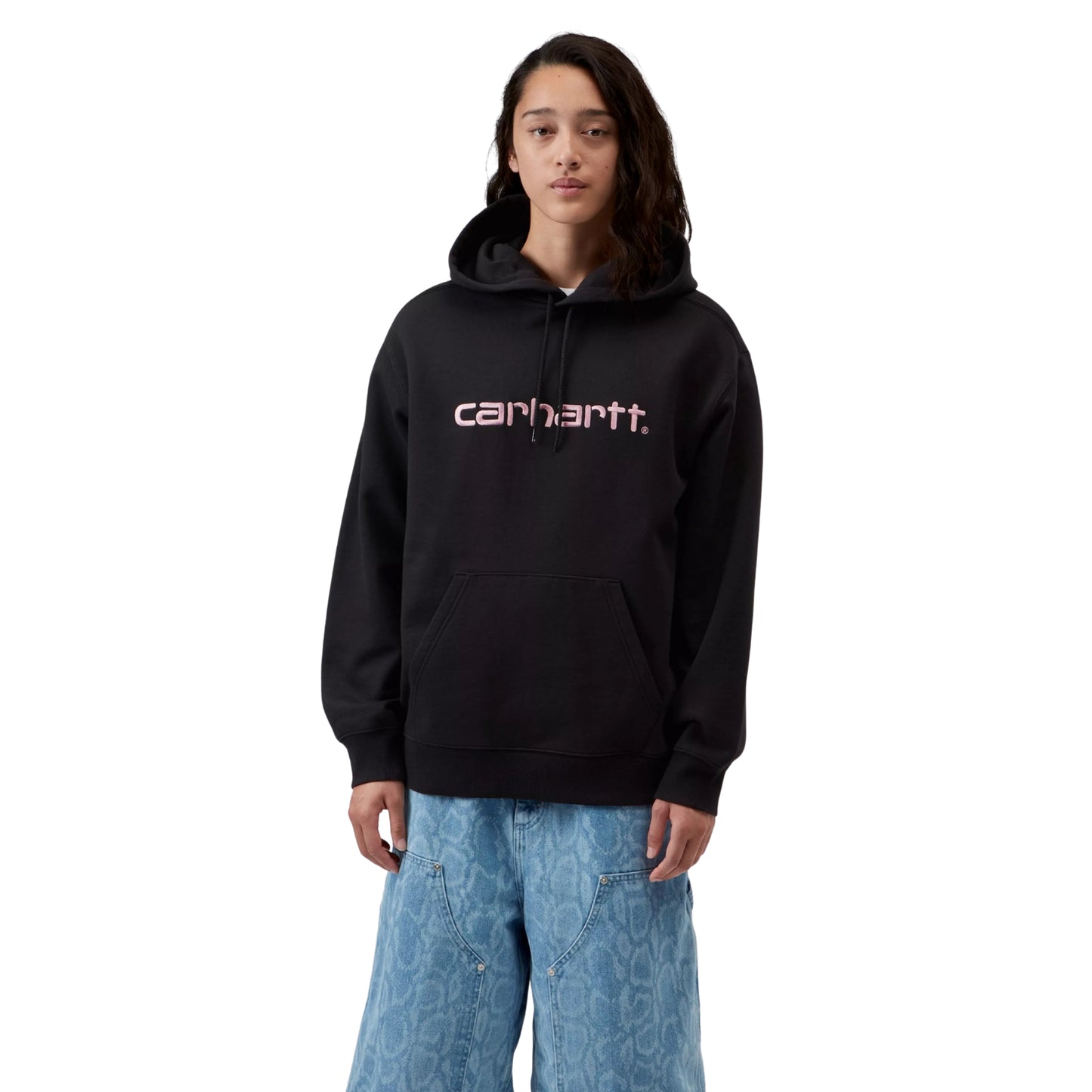 Sweat com carapuço para mulher Carhartt WIP W' Hooded Carhartt Sweatshirt em Black / Hortensia — vista frontal com modelo, meio corpo, logo Script "carhartt." bordado em Hortensia no peito, capota com cordão, combinado com calças largas de ganga Carhartt WIP.