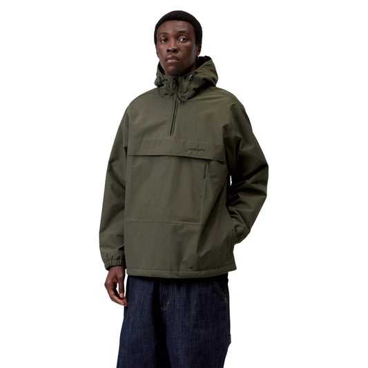 Anorak Carhartt WIP Windbreaker Pullover em Cypress / Black — modelo masculino de frente, meio corpo, gorro preto, capuz levantado com cordão e ajustador plástico preto, fecho de correr a meio do peito em Black, logótipo "carhartt." impresso no bolso frontal, bolso lateral com puxador de fecho preto visível, punhos elásticos, nylon Supplex® verde militar Cypress, fundo branco.
