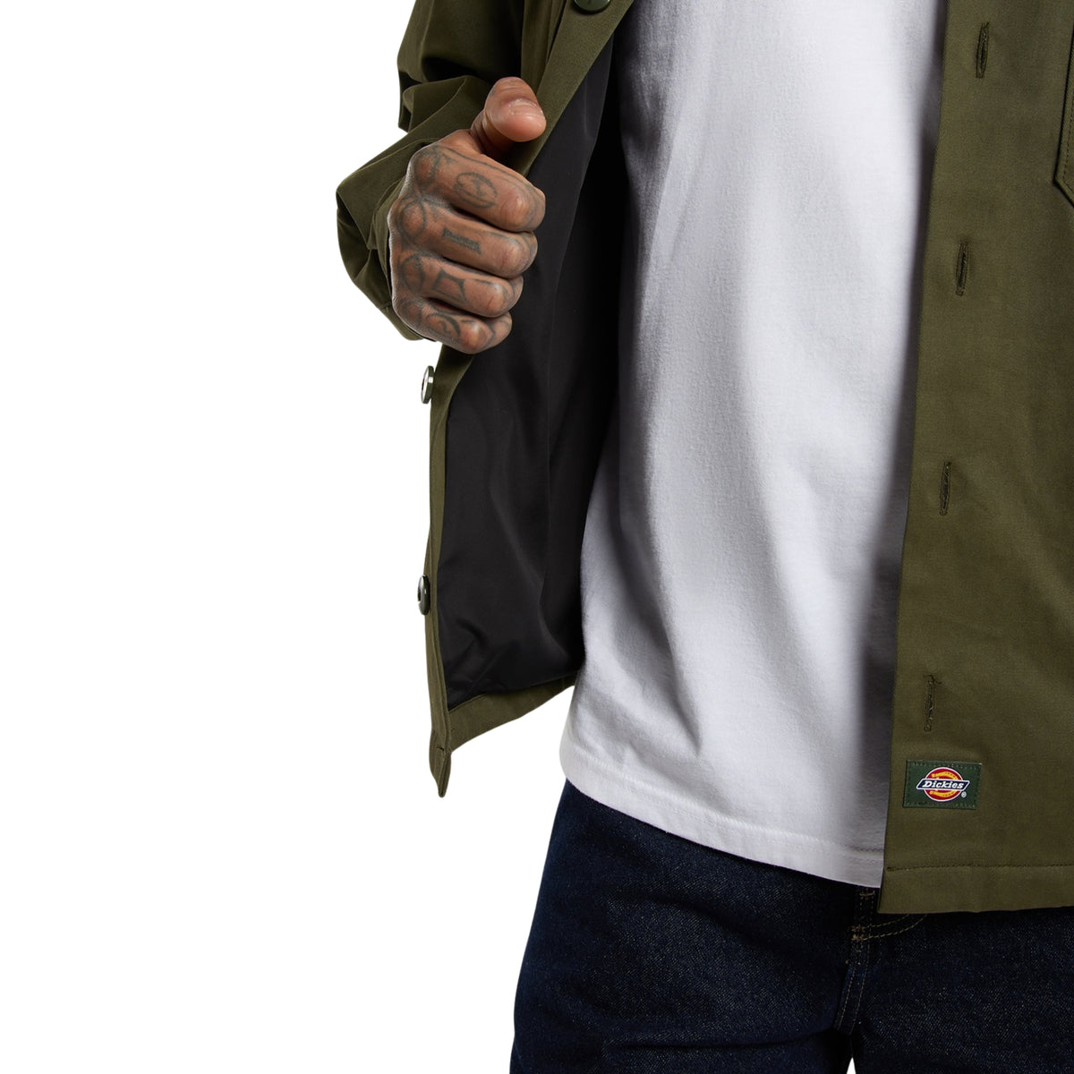 Casaco Dickies 247 em Deep Depths, close-up da frente aberta no modelo, revelando o forro interior escuro e a etiqueta tecida Dickies junto à bainha.