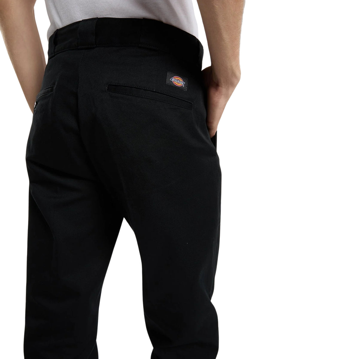Calças Dickies 247 Slim Work Pant em Preto — detalhe traseiro em close, tecido de algodão preto, bolso traseiro ribeteado com etiqueta woven Dickies vermelha, pinças traseiras e cintura com passadores, fundo branco.