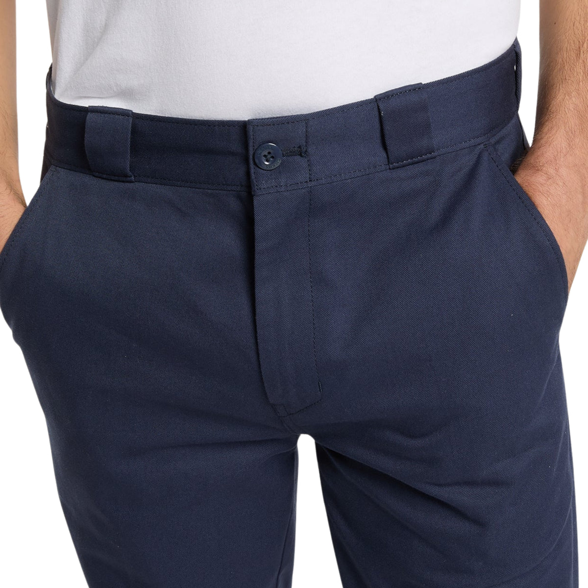 Calças Dickies 247 Slim Work Pant em Dark Navy — detalhe frontal em close, cintura e fecho de botão oculto, bolsos laterais com mãos apoiadas, tecido de algodão azul-marinho escuro, fundo branco.
