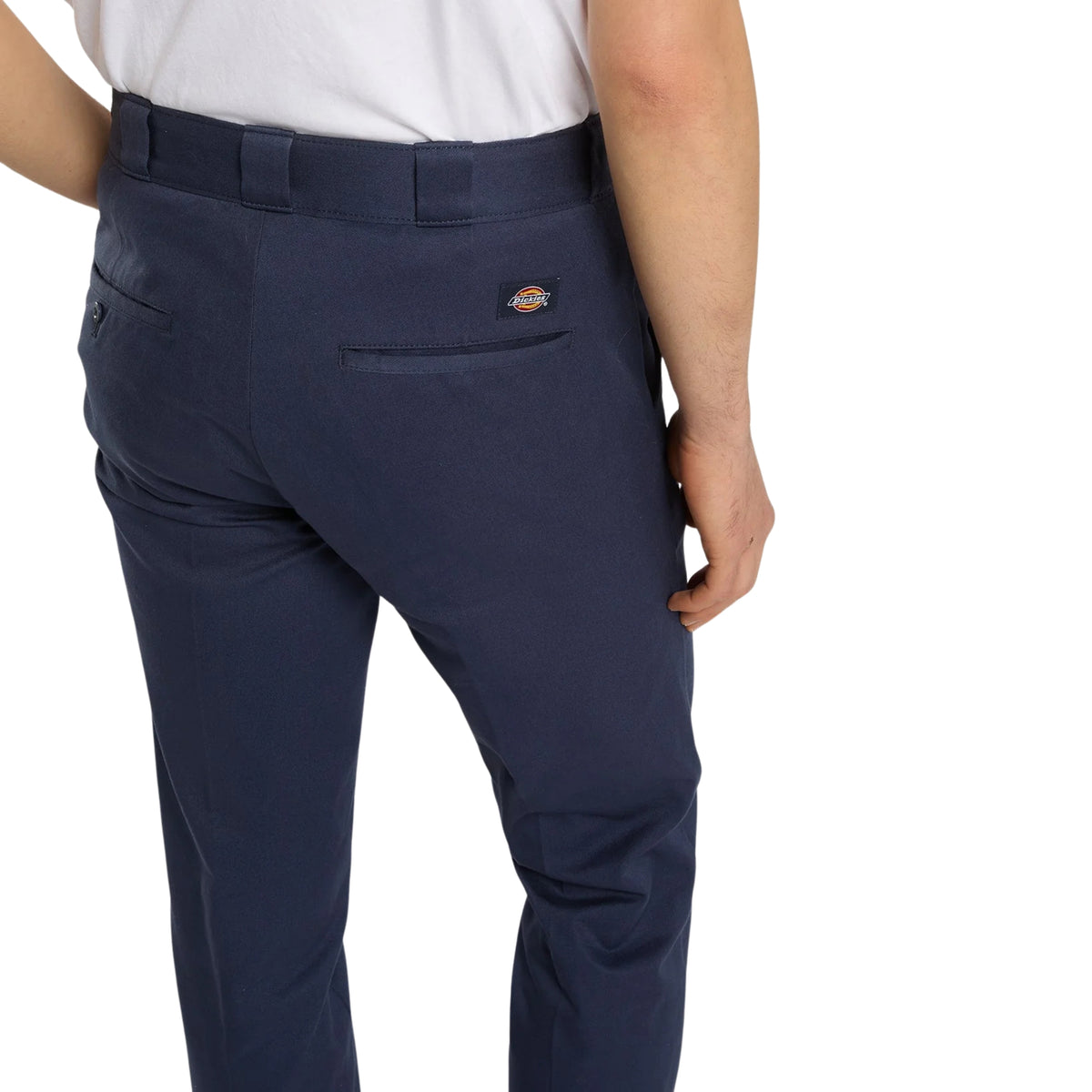 Calças Dickies 247 Slim Work Pant em Dark Navy — detalhe traseiro em close, bolso ribeteado com etiqueta woven Dickies laranja e branca, passadores para cinto e tecido de algodão azul-marinho escuro, fundo branco.