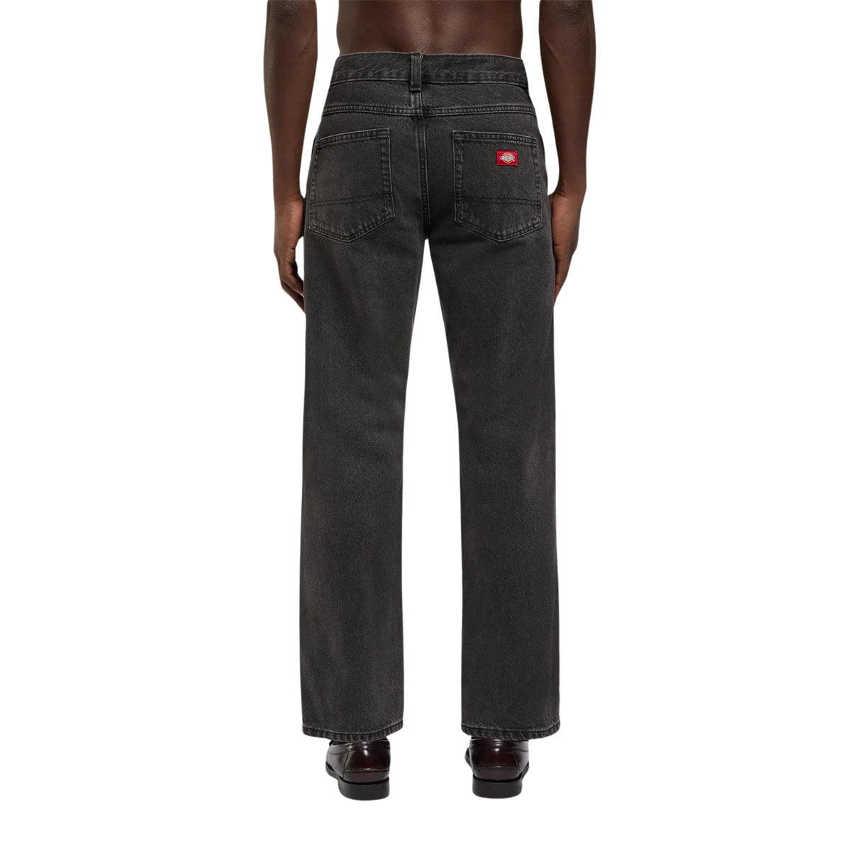 Calças de ganga Dickies 983 Regular Straight em preto lavado, vistas de costas no modelo, com dois bolsos traseiros e etiqueta vermelha.