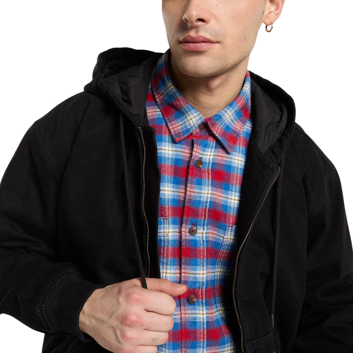 Pormenor do capuz, cordões ajustáveis e fecho do casaco Dickies Hilham preto, sobre uma camisa aos quadrados.