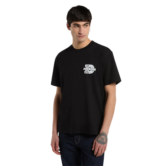 T-shirt de manga curta Dickies Minden em Preto — modelo de frente, t-shirt preta com pequeno estampado Dickies Quality Workwear no peito esquerdo, jeans azul-escuro e sapatilhas pretas, fundo branco.