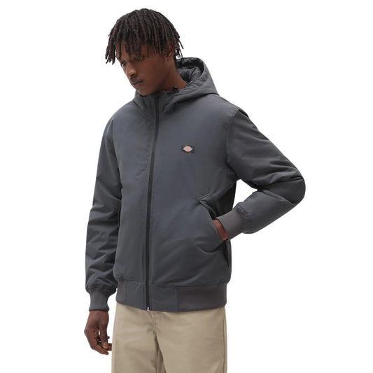 Casaco Dickies New Sarpy em Charcoal fechado em modelo de frente, com capuz, logótipo no peito e mão no bolso lateral.