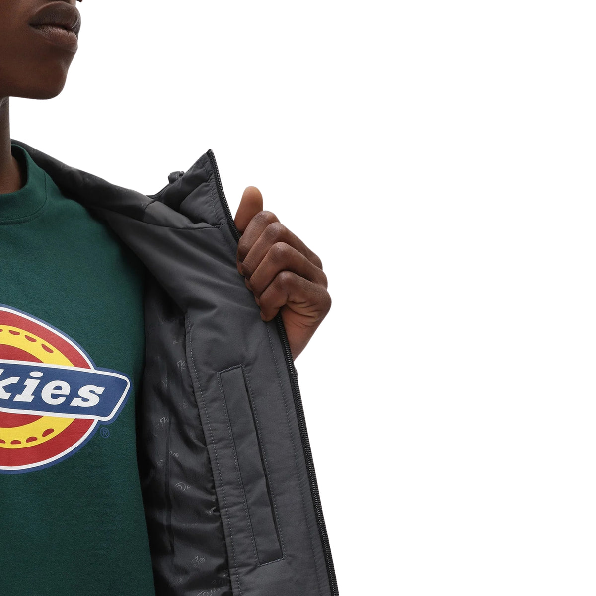 Pormenor do casaco Dickies New Sarpy em Charcoal aberto pelo modelo, mostrando o forro com pequenos motivos e a abertura do bolso interior.
