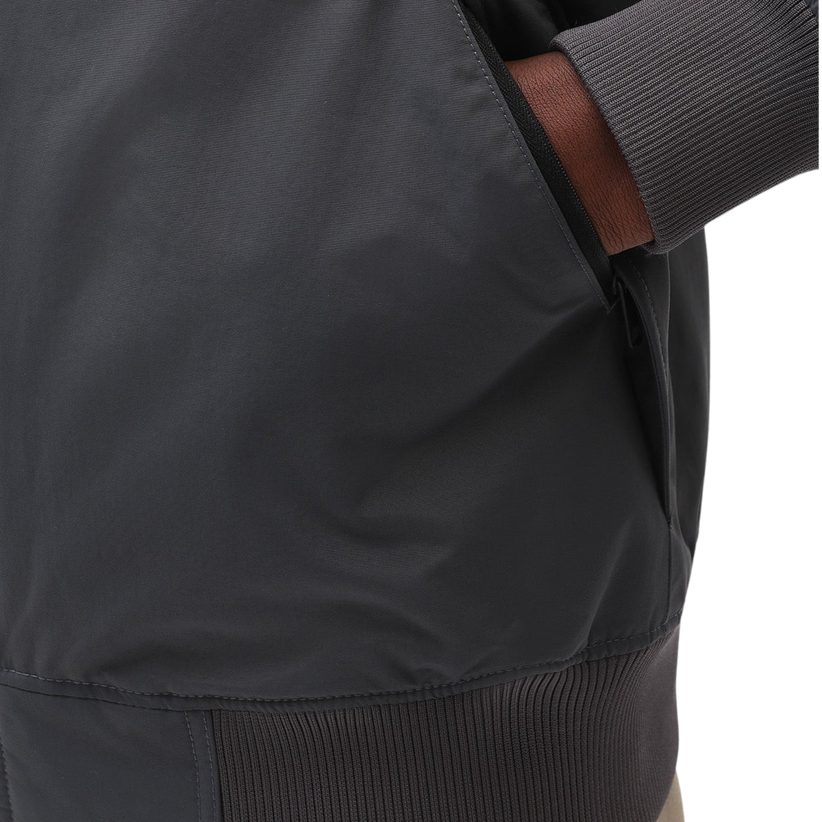 Pormenor do bolso lateral do casaco Dickies New Sarpy em Charcoal, com a mão no bolso, punho e bainha canelados.