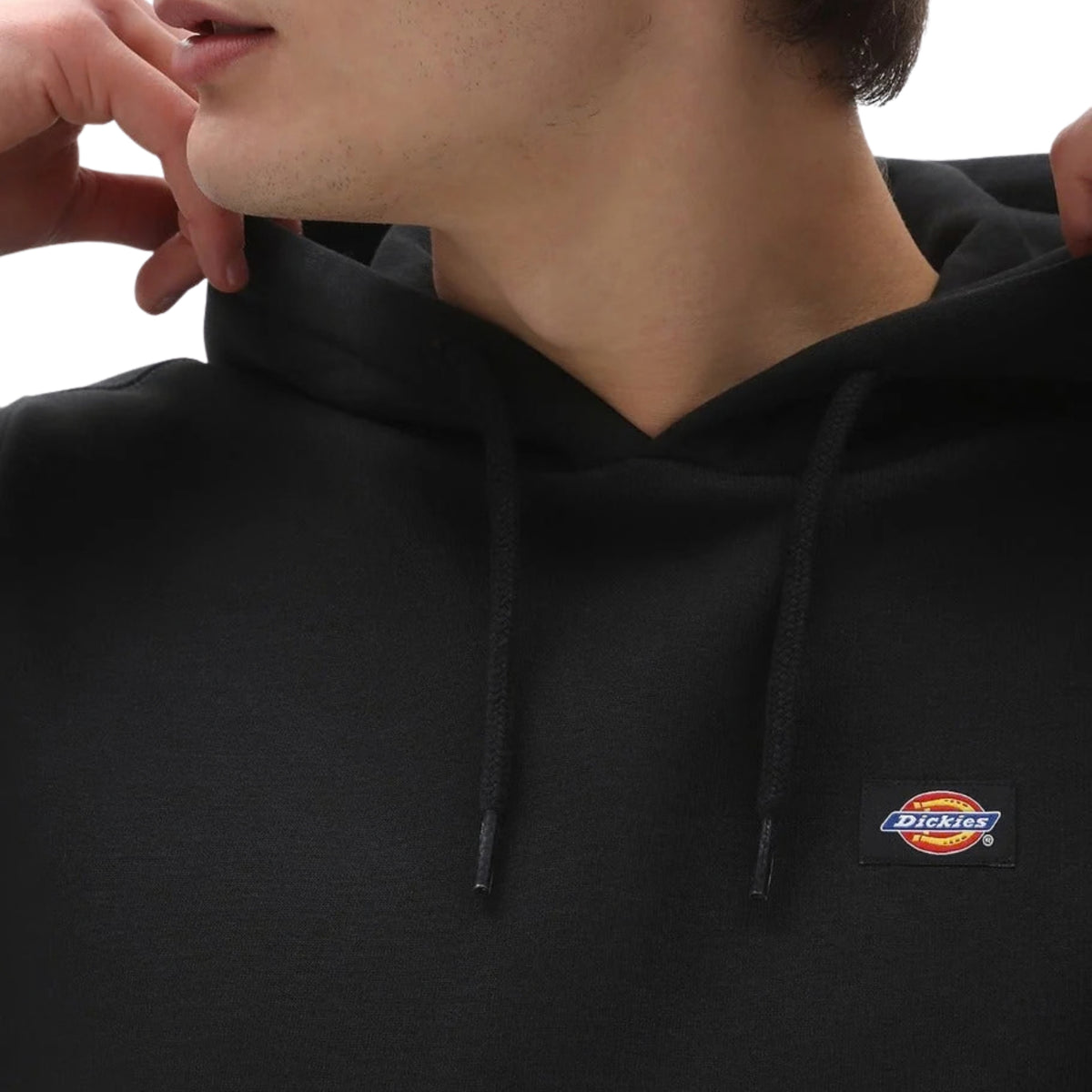 Sweat com carapuço Dickies Oakport em Preto — close-up do peito com patch bordada Dickies e cordão duplo da carapuço.