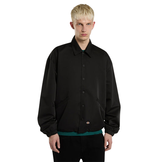 Casaco coach Dickies Parks em Preto, vista frontal em plano médio, com gola dobrada, fecho de molas e etiqueta Dickies junto à bainha.