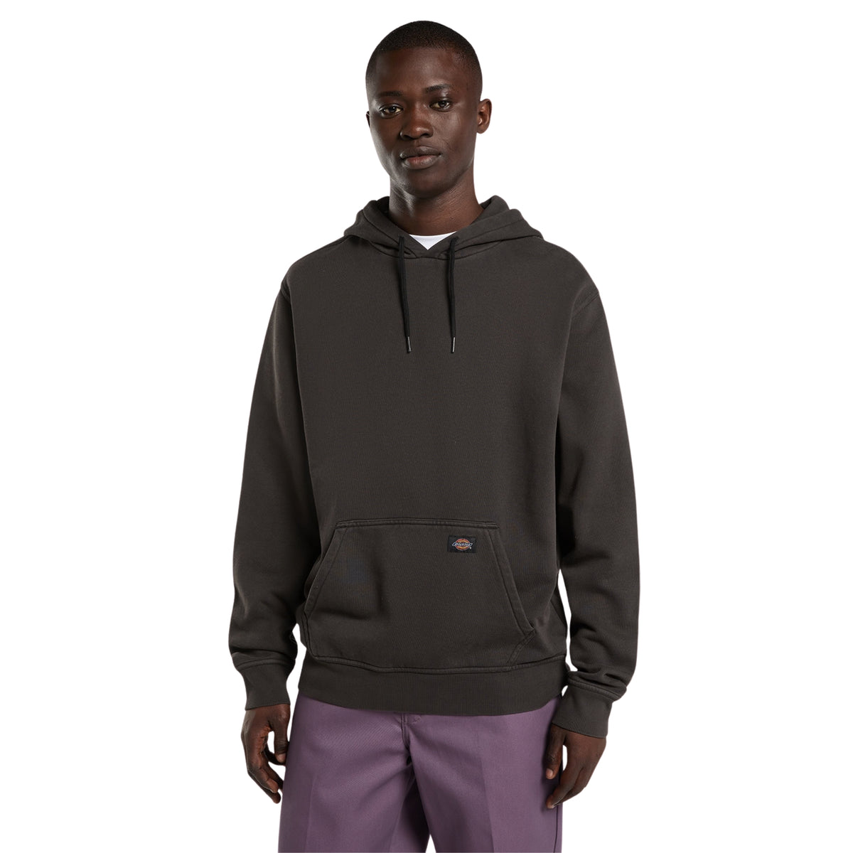 Sweat com carapuço Dickies Sutcliffe em Preto, vista frontal em plano médio no modelo, com cordões, bolso canguru e etiqueta Dickies no bolso, combinada com calças roxas.